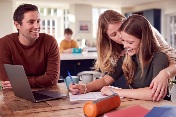 Parents Helping Teenage Daughter Homework Sitting Kitchen Table Home Using — Foto Stock