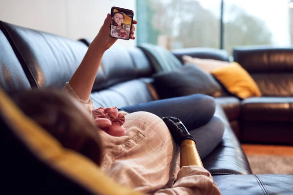 Zwangere Vrouw Met Prothetische Arm Nemen Selfie Liggend Sofa Thuis — Stockfoto