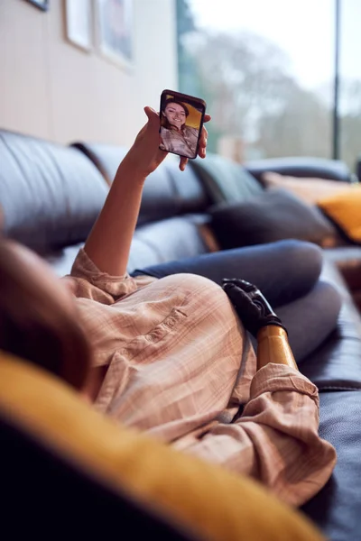 Pregnant Woman Prosthetic Arm Taking Selfie Lying Sofa Home Putting —  Fotos de Stock
