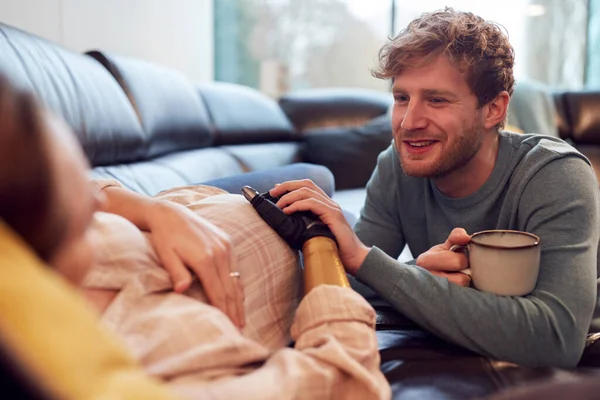 Loving Pregnant Couple Woman Prosthetic Arm Lying Sofa Home Together — Fotografia de Stock