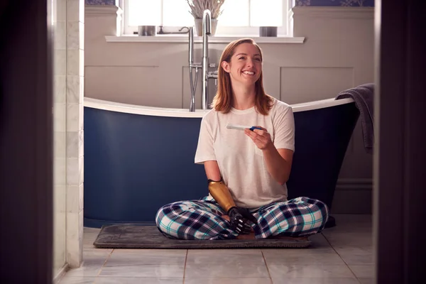 Excited Woman Prosthetic Arm Sitting Bathroom Floor Positive Pregnancy Test — Stock Photo, Image