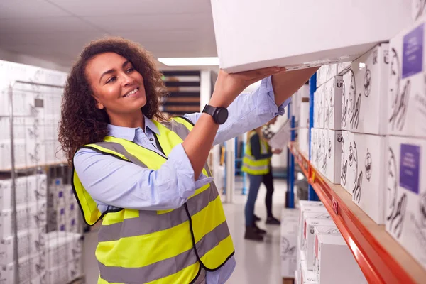 Trabajadora Dentro Almacén Ocupado Poniendo Caja Estante — Foto de Stock