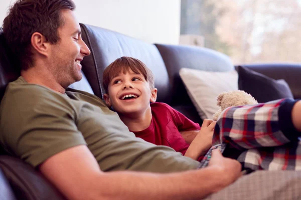 Father Son Toy Dog Sitting Sofa Pyjamas Together Watching — Stock Photo, Image