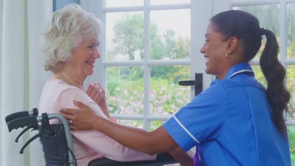 身着制服的女性护理人员与坐在轮椅上的抑郁老年妇女在养老院里交谈 动作缓慢 — 图库视频影像