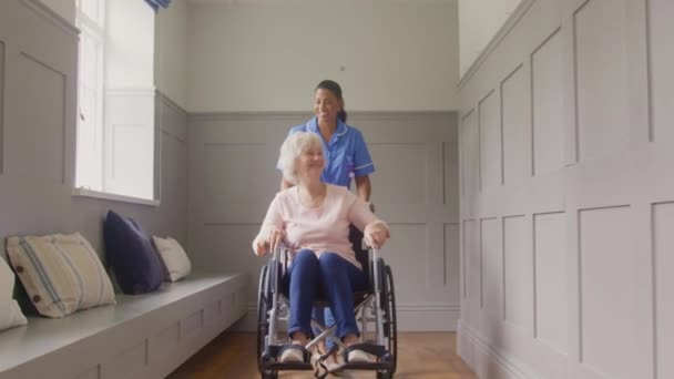 Старшу Жінку Вдома Інвалідному Візку Штовхає Працівник Догляду Жінкою Уніформі — стокове відео