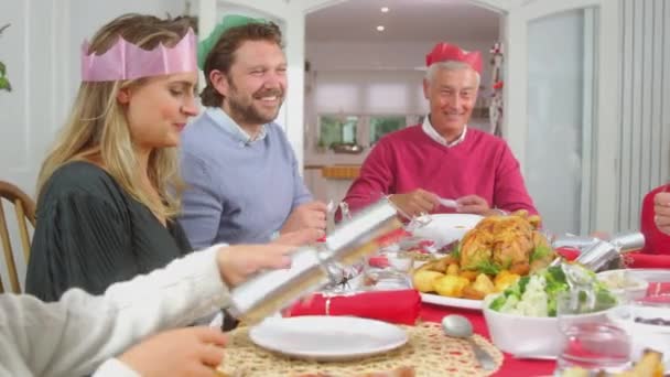 Wielopokoleniowa Rodzina Papierowych Kapeluszach Czytająca Świąteczne Żarty Krakersów Jedząc Razem — Wideo stockowe