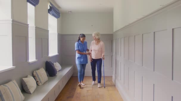 Seniorin Hause Mit Gehstock Die Von Pflegerin Uniform Unterstützt Wird — Stockvideo