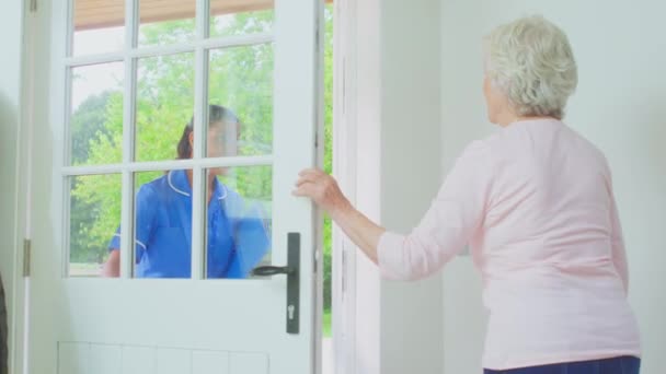 Senior Woman Home Using Walking Frame Greeting Female Care Worker — Stok video