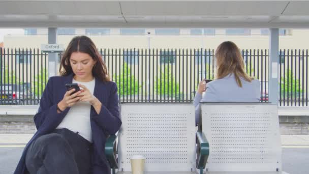 Two Businesswomen Commuting Work Waiting Train Station Platform Looking Mobile — Stock Video
