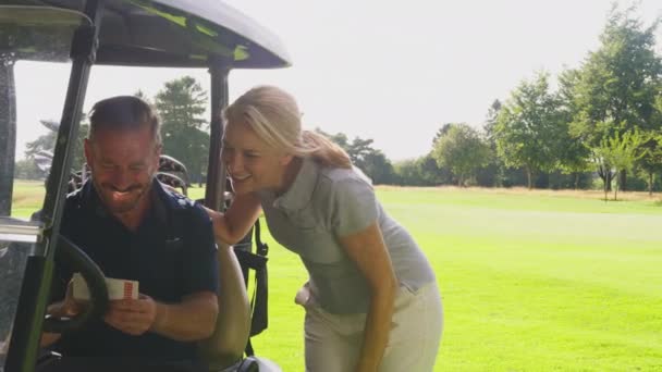 Mature Couple Playing Golf Sitting Buggy Checking Score Card Together — Wideo stockowe