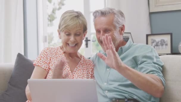 Smiling Senior Retired Couple Sitting Sofa Home Making Video Call — Stockvideo