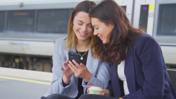 Двоє Бізнесменів Які Прагнуть Працювати Чекають Поїзд Платформі Дивлячись Мобільний — стокове відео