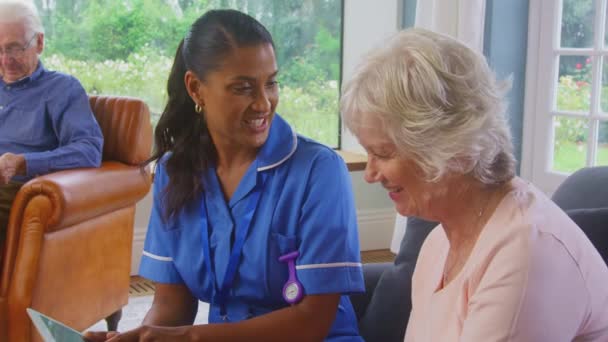 Oudere Paar Thuis Met Vrouw Gesprek Met Vrouwelijke Verpleegkundige Zorgverlener — Stockvideo