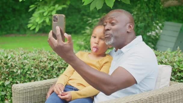 Bunicul Trăgând Fețe Nepoata Luând Selfie Telefonul Mobil Grădină Acasă — Videoclip de stoc