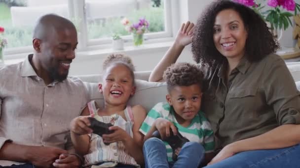 Parents Playing Video Game Children Sitting Sofa Lounge Home Shot — Stockvideo