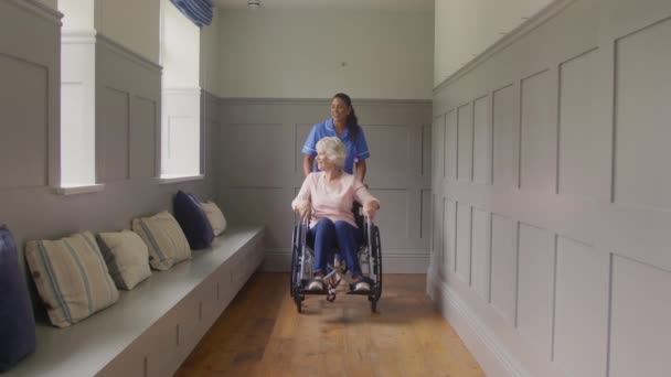 Wanita Senior Rumah Yang Duduk Kursi Roda Didorong Oleh Petugas — Stok Video