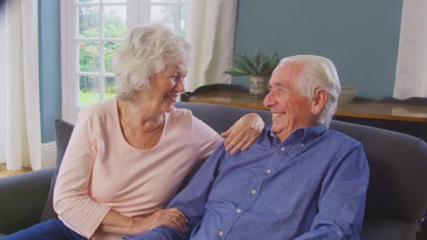 Loving Senior Couple Sitting Sofa Home Talking Laughing Together Shot — Stockvideo