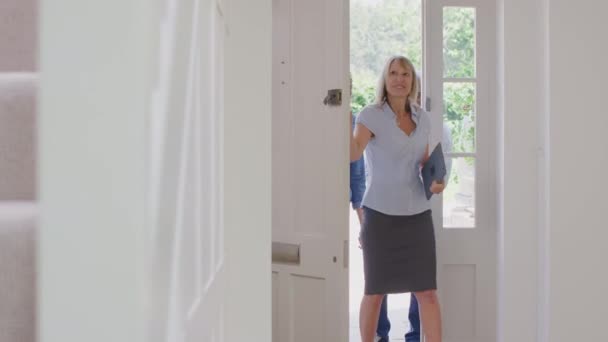 Female Realtor Opening Front Door Showing Couple Potential New House — Vídeos de Stock