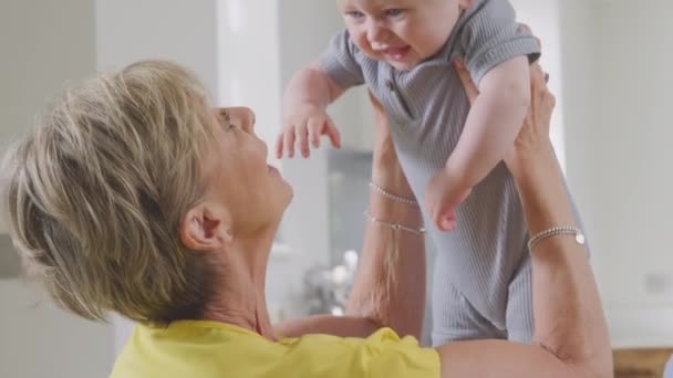 Grandmother Looking Baby Grandson Home Lifting Him Air Making Him — 图库视频影像