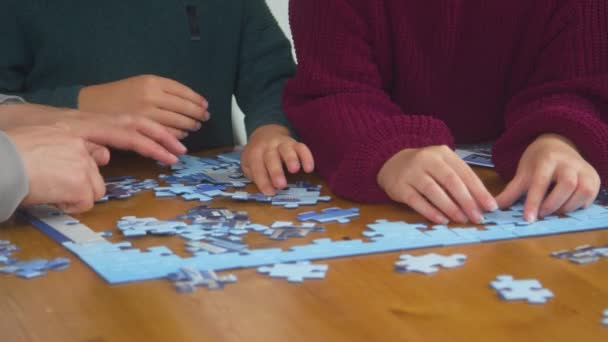 Close Children Parents Sitting Table Home Doing Jigsaw Puzzle Together — Video