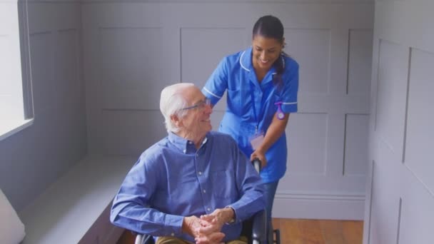 Senior Man Home Wheelchair Being Pushed Female Care Worker Uniform — Vídeo de Stock