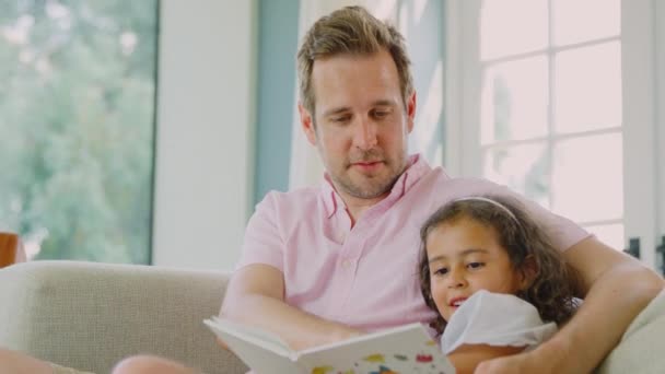 Ojciec Córka Siedzą Razem Kanapie Domu Czytając Książkę Nakręceni Zwolnionym — Wideo stockowe