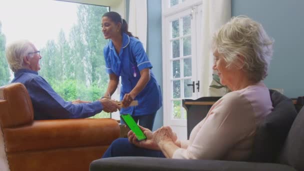 Pflegerin Uniform Bringt Senioren Die Hause Wohnzimmer Stuhl Sitzen Essen — Stockvideo