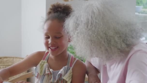 Großmutter Sitzt Mit Enkelin Tisch Und Hilft Ihr Beim Schulbesuch — Stockvideo