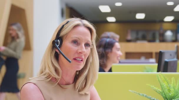 Camera Tracks Screen Showing Mature Businesswoman Wearing Wireless Headset Microphone — Stok Video
