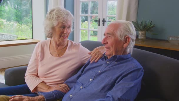 Loving Senior Couple Sitting Sofa Home Talking Laughing Together Shot — Wideo stockowe