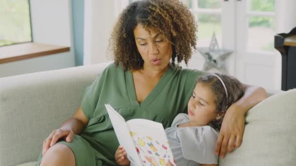 Matka Córka Siedzą Razem Kanapie Domu Czytając Książkę Zastrzeleni Zwolnionym — Wideo stockowe
