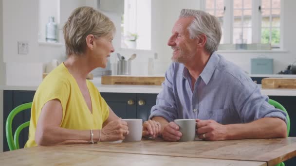 사랑하는 부부는 마시기 부엌에 식탁에둘러 이야기를 나누고 웃으면서 천천히 가운데 — 비디오