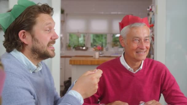 Senior Father Adult Son Paper Hats Reading Christmas Cracker Jokes — Stock Video