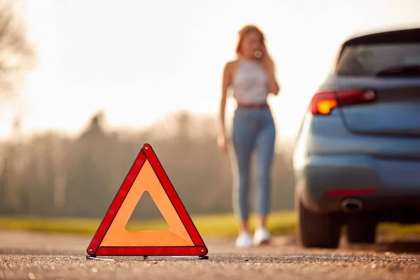 汽车在路上抛锚的危险警告三角标志 妇女在背后呼救 — 图库照片