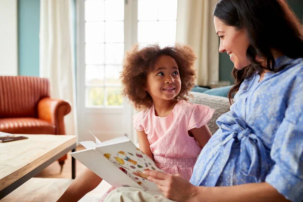 Mãe Grávida Filha Relaxando Sofá Casa Leitura Livro Juntos — Fotografia de Stock