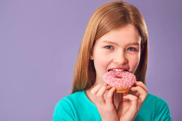 Mor Arkaplan Karşısında Donut Yiyen Kızın Stüdyo Portresi — Stok fotoğraf