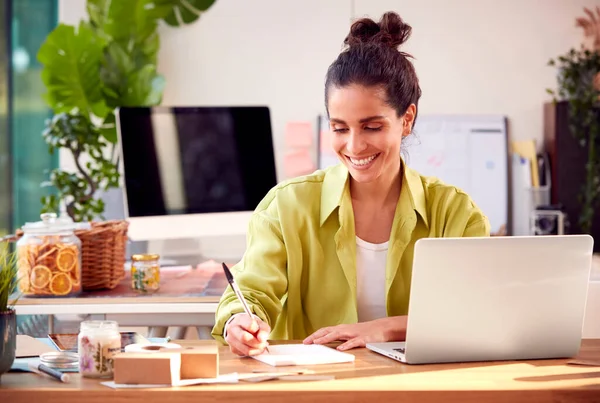オンラインビジネスを営む女性 自宅でブティックキャンドルを作るノートパソコンで働く — ストック写真
