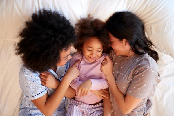 Overhead Skott Familj Med Två Mammor Bär Pyjamas Spela Sängen — Stockfoto