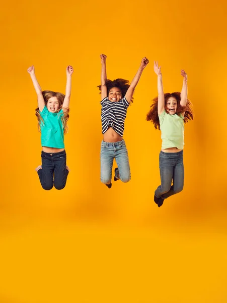 Studio Shot Van Energieke Kinderen Springen Lucht Met Uitgestrekte Armen — Stockfoto