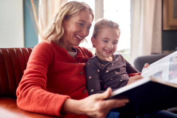 Grandmother Granddaughter Looking Photo Album Lounge Home Together — 스톡 사진