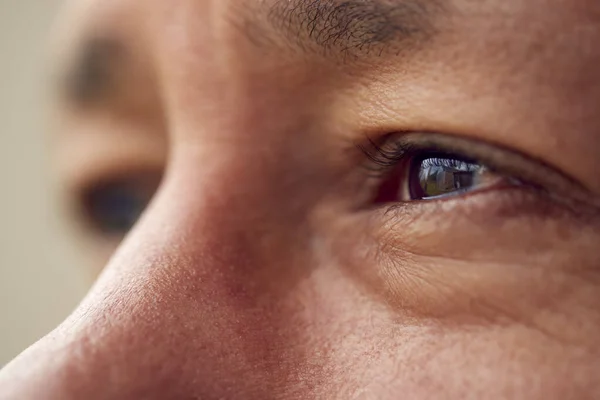 Zbliżenie Oczu Dojrzałego Mężczyzny Wyglądającego Przez Okno — Zdjęcie stockowe