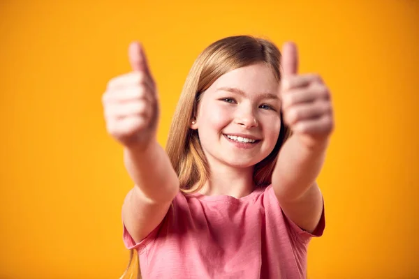 Studio Portrait Smiling Young Girl Making Thumbs Gesture Shot Yellow —  Fotos de Stock