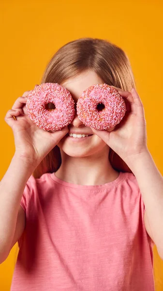 Studioporträt Eines Mädchens Das Vor Gelbem Hintergrund Zwei Donuts Vor — Stockfoto