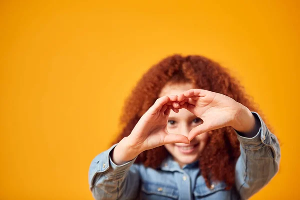 Studio Portrait Smiling Girl Making Heart Shape Hands Yellow Background — Stock Photo, Image