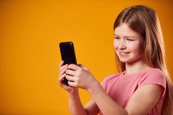 Studio Portrait Young Girl Using Mobile Phone Yellow Background — Stock Photo, Image