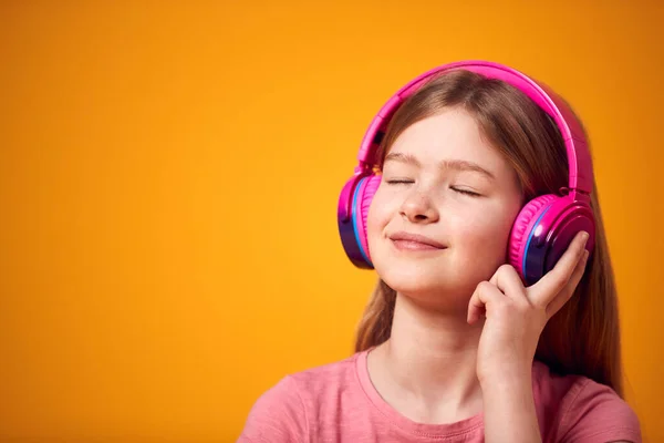 Studio Strzał Uśmiechnięta Młoda Dziewczyna Słuchając Muzyki Słuchawki Żółtym Tle — Zdjęcie stockowe