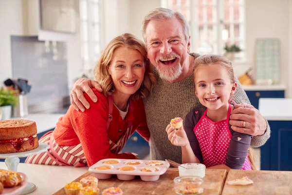 Porträt Von Großeltern Mit Enkelin Essen Hausgemachte Cupcakes Küche Hause — Stockfoto