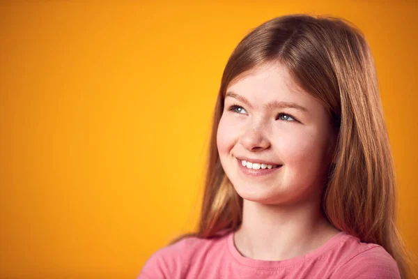 黄色の背景の下で撮影された笑顔の若い女の子の肖像画 — ストック写真