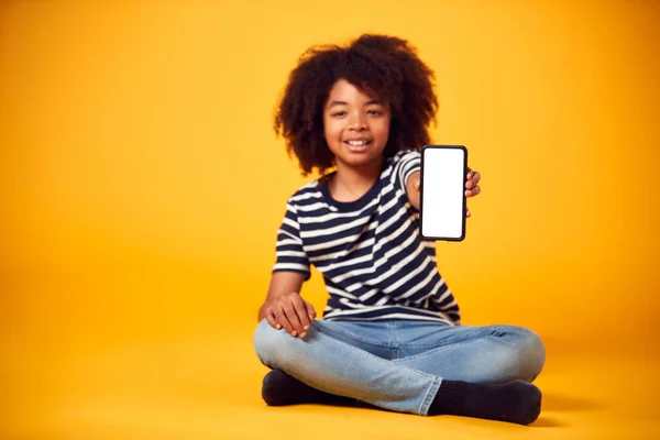Студийный Портрет Мальчика Демонстрирующего Мобильный Телефон Экраном Социальных Сетях Жёлтом — стоковое фото