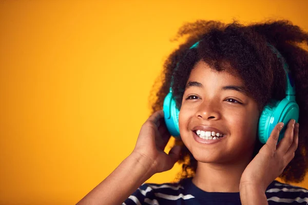 Studio Strzał Uśmiechnięty Młody Chłopiec Słuchając Muzyki Słuchawki Żółtym Tle — Zdjęcie stockowe